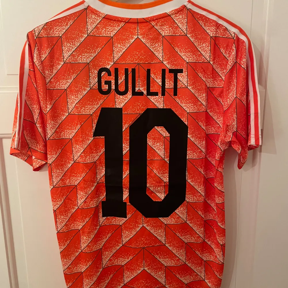 Säljer en Ruud Gullit fotbollströja med nummer 10 på ryggen från Nederländerna, version år 1988. Helt ny med tagg. Tröjan är en reprint. Storlek: M. Ansvarar ej för postens slarv. Endast handtvätt. Gnugga ej på blöta prints.. Sport & träning.