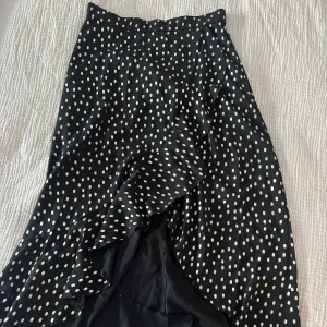 Omlott kjol  - Omlott kjol med skirt tyg samt undertyg, guldiga prickar. Dragkedja i sidan. Knappt använd! Märke: valerie