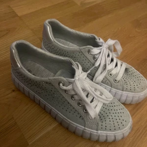 Vita sneakers från Graceland - Ett par ljus gröna sneakers från Graceland med snörning och dekorativa små nitar. Skorna har en tjock sula och är i storlek 38. längst fram är de typ 3 nitar som lossnat, derför säljs de för priset, bara höra av er! priset kan diskuteras!💕