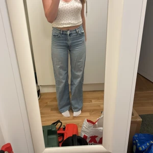 Ljusblåa jeans  - Högmidjade vida ljusblåa jeans från Monki. Bra skick överlag men små slitna på fickorna.