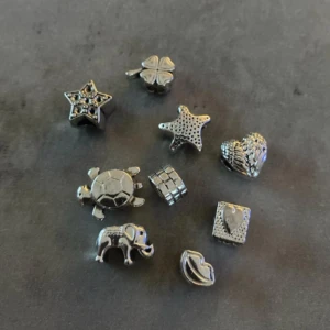 Smyckesberlocker i olika former - Ett set med olika smyckesberlocker i silverfärg. Setet innehåller berlocker i form av en stjärna, fyrklöver, sköldpadda, elefant, hjärta, läppar och en kub. dessa är köpta i England och passar fint till pandoras armband