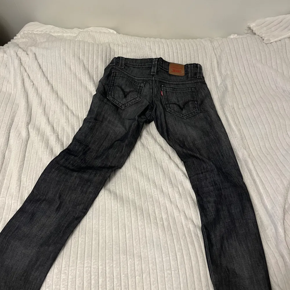 Lågmidjade Levi’s jeans som är mörkgrå/svarta. En rak modell i storlek 26/32 men tyvärr är de försmå för mig. Midjan 40cm och innerbenslängden är 82cm☺️Skriv om du har några frågor💕 Priset ej hugget i sten!. Jeans & Byxor.