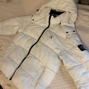 Calvin klein jacka - Vit Calvin Klein dunjacka utan några skador. Jag säljer då den inte längre passar mig. Dm för mer info eller bilder.
