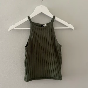 Grönt linne H&M - Jättefint mörkgrönt linne från H&M i storlek xxs. Tröjan är stretchig och passar även jättebra för xs, s och M. 