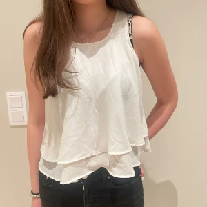Vit topp - Knappt använt vitt volanglinne med en slits i ryggen perfekt topp för sommaren eller varmare väder.