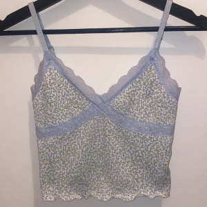 Blommig topp - Ribbad topp med blom mönster och med  spets. Toppen är från H&M divided i stl xs!  