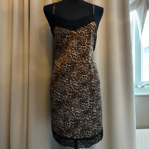 Leopardklänning - Såååå snygg sidenklänning i leopard-mönster med spets uppe och nere. Super trendig till fest!