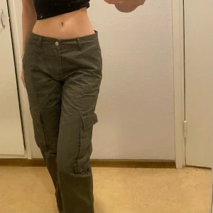 Lågmidjade cargo - Ett par jätte snygga lågmidjade cargo byxor, mörk gröna och knappt använda. Raka i längden. Passar mig i längden som är ca 170cm 💚