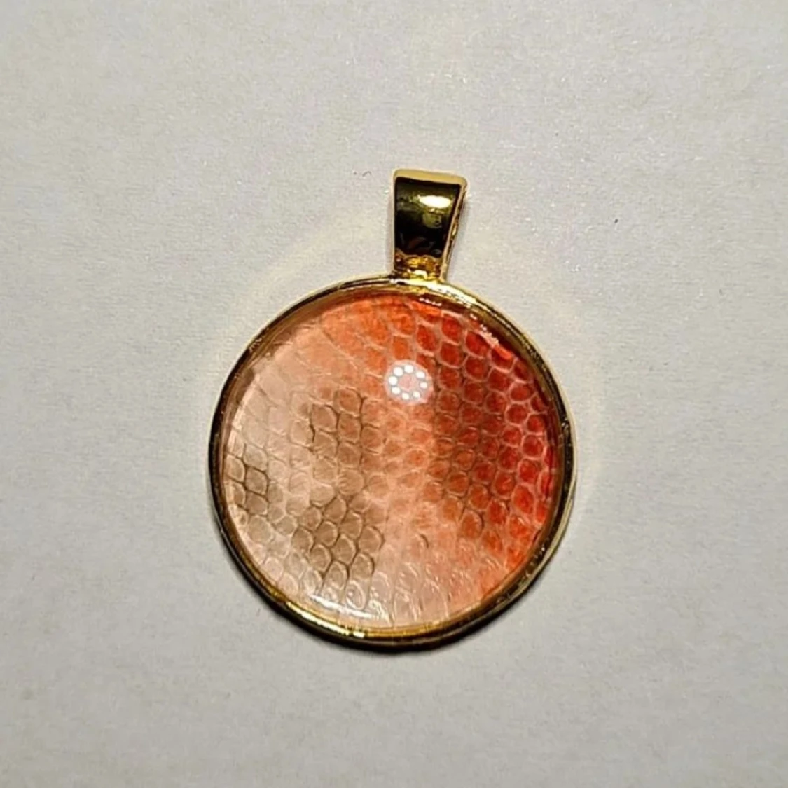 Röd och vit berlock på ormskinn