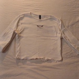 Vit långärmad tröja - Vit långärmad tröja med en mönster i mitten, ett hjärta med vingar. Helt oanvänd eftersom den är tyvärr inte i min storlek men den är verkligen jättefin. 