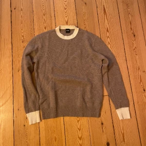 Cashmere, boss tröja - Säljer min cashmere ull tröja (10% cashmere, 90% ull), i storlek medium. Denna tröja passade mig aldrig och har därför knappt används. Nypris 2300, mitt pris 400. Tröjan är beige och vit runt ärmarna och kragen. Väldigt snygg och stilren!