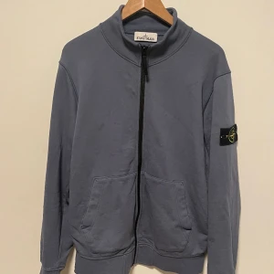 Stone Island Zipup, Sz Large - En grymt snygg sweatshirt från stone island som passar med nästan vad som helst. Patchen är i perfekt skick pch aldrig tvättat tröjan med den på. Tyvärr har tröjan små fläckar på 3dje bilden, inte försökt ta bort dom så kan inte garantera att de går.