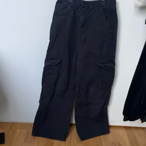 Svarta byxor  - Byxor är vida  De har 6 olika fickor  Man kan Justera dem i midjan 