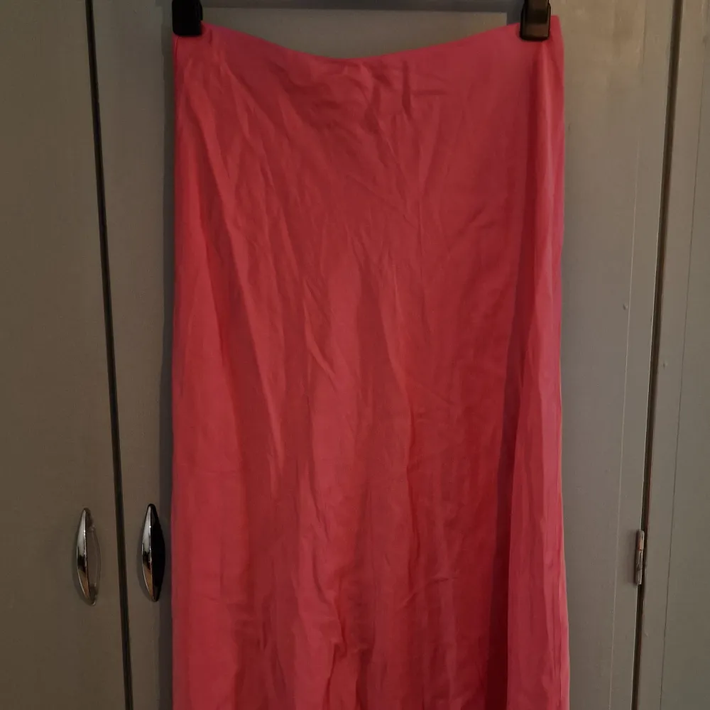 En lång kjol me glansigt tyg (försökte visa de på sista bilden). Vet inte vad de är för märke, står bara 