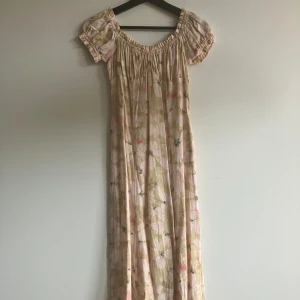 Sommarklänning  - Perfekt sommarklänning. Blommigt mönster med slits och puffiga detaljer runt ringning och ärmar.