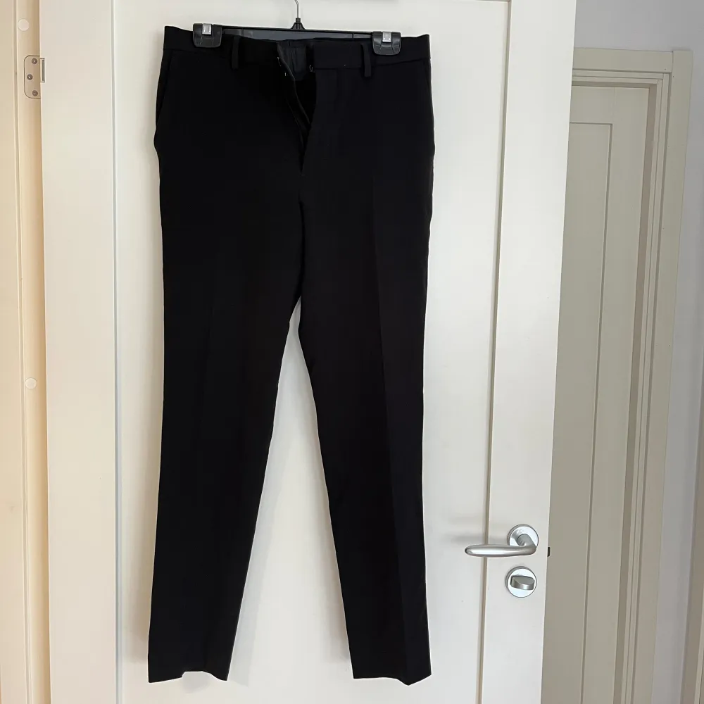 Svarta kostymbyxor med pressveck i mycket fint skick och skönt material. 63% polyester 33% viskos 4% elastan Skriv vid övriga frågor. . Farkut & Housut.