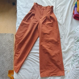 Orangea byxor - Vida byxben med tajtmidja, har sytt in dem lite i vecken och det har gått upp lite så det går att sprätta upp eller sy ihop. 