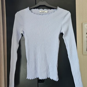 Ljusblå ribbad tröja  - En ljusblå ribbad tröja från NA-KD i storlek S. Den har en bra passform och är i gott skick. 