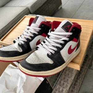 Nike Jordan 1 Mid red/black/white - Storlek 42, ganska använda men funkar fortfarande. Är smutsiga på bild så skulle se bättre ut efter en tvätt.  Original låda medföljer.  Det ni ser på bild är det ni får. 