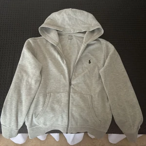 POLO Ralph Lauren Hoodie - Storlek: S Krympt en del i tvätten så den kan vara lite mindre än förväntat. Snörren till huvan finns ej. Förövrigt så är skicket på hoodien väldigt bra