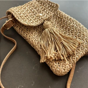 Snygg somrig  Mobilväska - Snygg smidig mobilväska. Avtagbar axelrem. Man får plats med något litet mer än mobil som tex kort, nycklar så den är superpraktisk. Trendig vävd väska. Crossbody