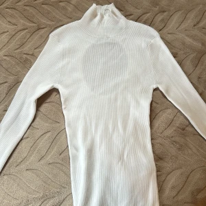 Långärmad polotröja  - En långärmad polotröja. I färgen vit. Oanvänd. Köpt på bikbok.