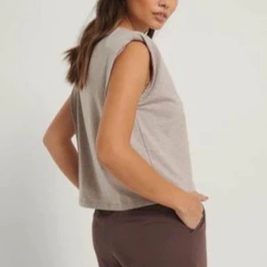 Ljusgrå topp storlek S och M  - Snygg topp med axelkuddar i en ljusgrå färg. Toppen är perfekt för både vardag och fest. Den är bekväm att bära och passar bra till jeans eller kjol. Finns i två storlekar, S och M 30kr/st