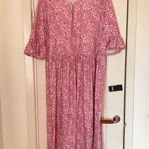 Småblommig klänning - Småblommig långklänning med volanger vid ärmslutet. Stl M enligt lapp men rymlig i passformen.  Aldrig använd då den tyvärr blev för stor för mig.
