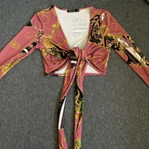 Knyt topp/ knytblus - En söt knyt topp med fint mönster , stretchiga material fint skick, använd en gång. Croppad 