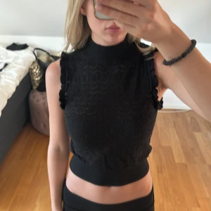 Stickad topp - En svart stickad topp med fint mönster och små volangdetaljer vid ärmarna🥰