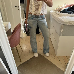 Lågmidjade bootcut jeans!!! - Snygga lågmidjade bootcut jeans i en jättesnygg blå färg 💓 MIDJEMÅTT: 37cm rakt över, Innerbenslängd:78cm Märket är ”Rexy” Obs knappen är lite lös o kan plockas ur, men de är inte svårt o man kan bara byta knapp!