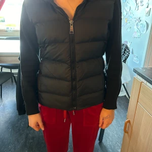 Moncler jacka  - Moncler jacka med stickade ärmar.  Reva på ena ärmen, går säkert att du snyggare så de inte syns.  Min dotter är 153cm lång och har storlek XS. Kan skicka fler bilder. 