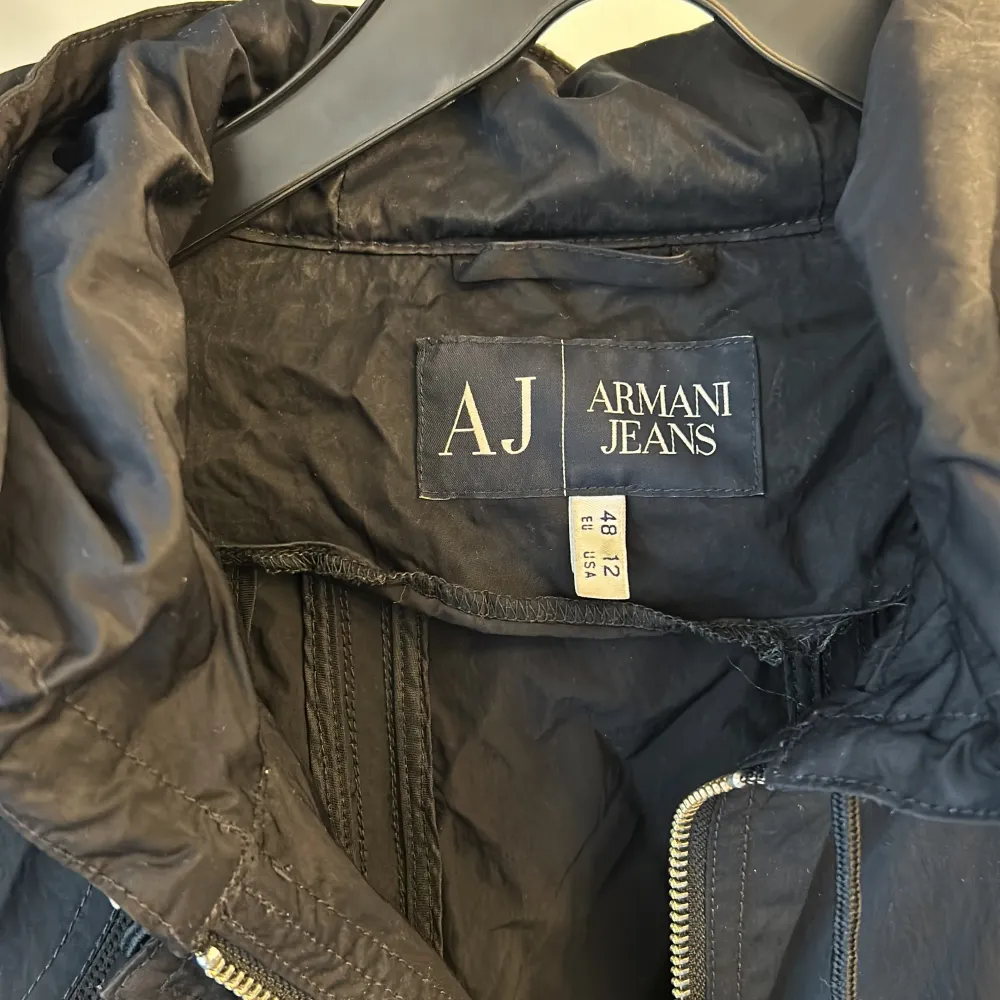 Mörkblå vårjacka från Armani jeans med fina detaljer och dragsko i midjan. Smal i modellen. Använt skick men fin. Lite ”prassligt” material. Stl EU 48 o US 12. Skulle jämställa det med typ dam L. Jackor.