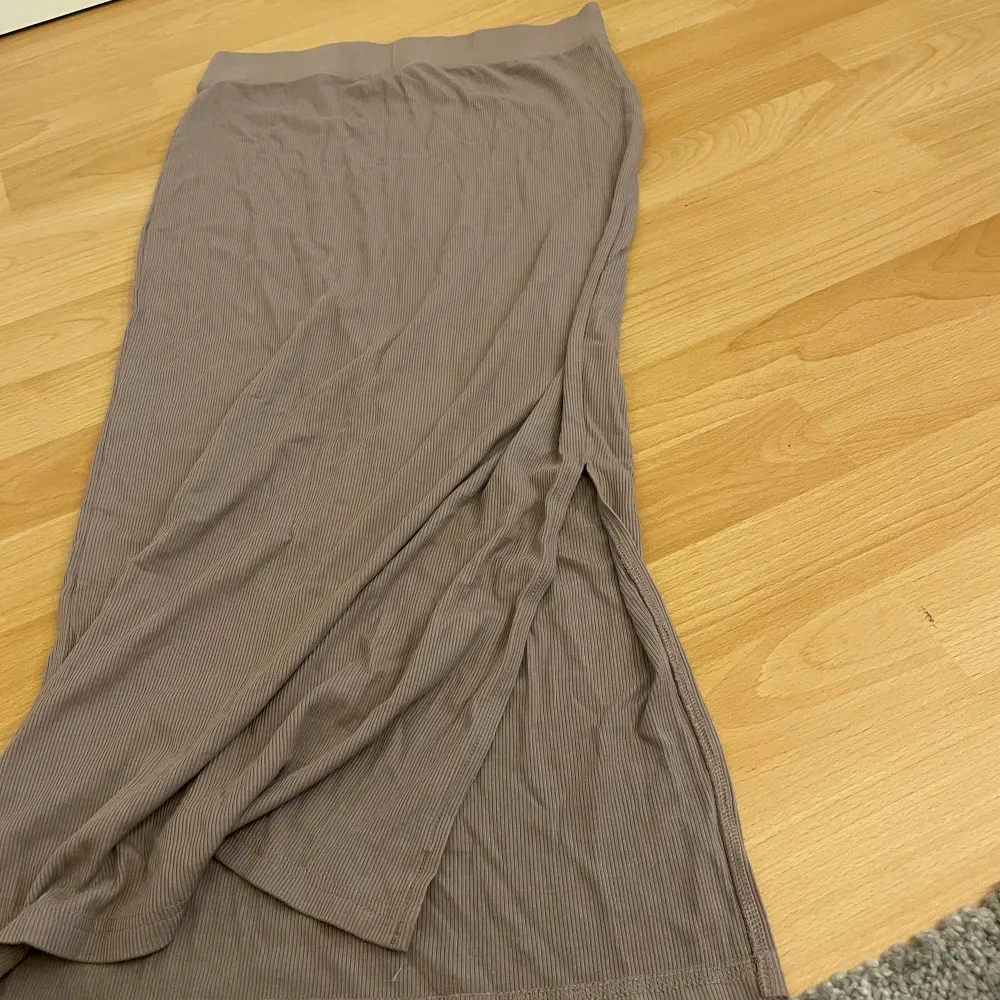 Säljer en mörk beige kjol med en sluta på sidan.. Hameet.