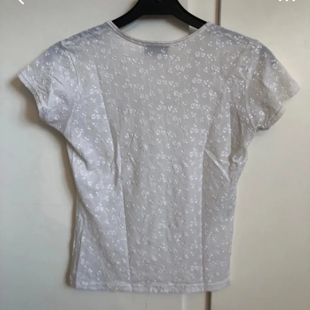 Söt vit T-shirt med broderade blommor ☺️ märkt som M men passar xs-s tycker jag. Toppar.