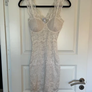 Vit spetsklänning från Nelly - Vit spetsklänning från Nelly, passar perfekt till studenten. Endast använd en gång. Storlek XS