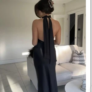 Zara svart klänning - Svart maxiklänning från zara. Perfekta balklänningen i satin. Djup i ryggen med knyte vid halsen. Såå himla fin klänning!