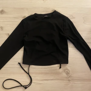 Svart top  - Säljer min  bershka top som är för liten som har en öppen rygg med snören på.  