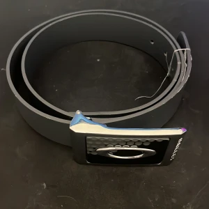 Vintage oakley bälte - Tja säljer det här feta Oakley bältet. Såldes runt 2000-tl och tillverkas inte längre vilket gör det väldigt exklusivt! Inprinsipt oanvänt.  100% Naturligt läder Snyggt metal spänne Oklippt  Skriv för frågor och funderingar, pris kan diskuteras!