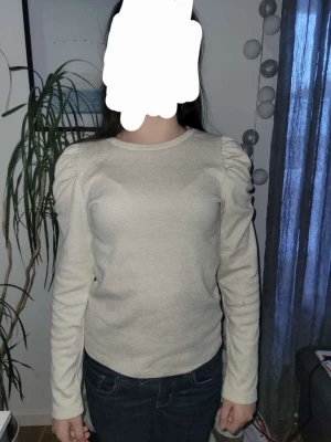 Beige tröja från lindex - En snygg beige tröja från Lindex. Den har några slags volanger vid axlarna.