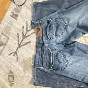 Lågmidjade jeans - Säljer dessa lågmidjade jeans då de inte passar💕 de har små slitningar längst ner på benet. Midjemåttet är 39 cm och innerbensmåttet är 86 cm💕