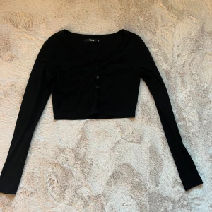 Svart tröja - En kroppad stickad svart tröja med knappar i mitten 