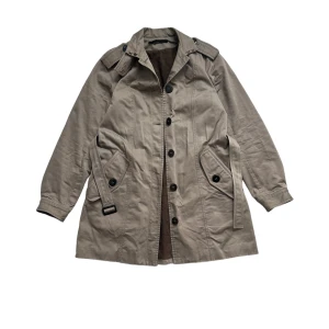 Acne trenchcoat kappa rock  - Fint använt skick, tecken på användning finns. Nå små fläckar och ett litet litet jack som visas på sista bilden. Storlek large i dam storlek, fungerar precis lika bra till herr som en small ish.
