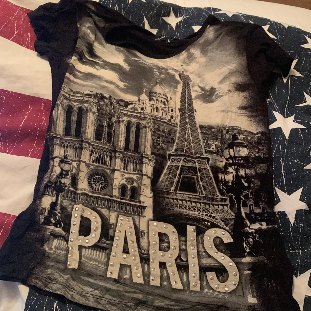 Svart T-shirt med paris sevärdigheter, köpt i paris, strlk 3 men skulle säga det passar S/M, köpte den för 700. T-shirts.