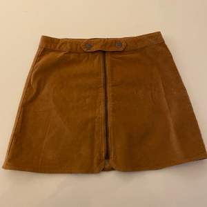 En brun/orange kjol från Zara. Är för barn men passar XS-S. Är lite kort! 
