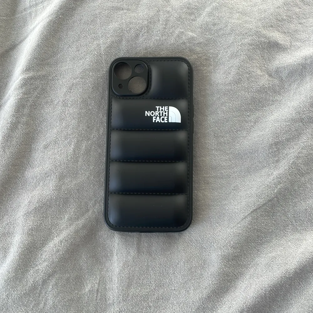 The North Face puffer mobilskal till iPhone 13 finns i både svart och vitt, skriv vilken färg du önskar . Övrigt.