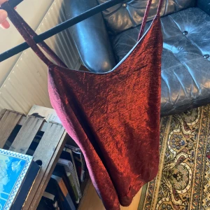 Röd klänning - Röd-svart klänning i glansigt material, från ”Fujo design”. Färgen i bild 2 stämmer inte riktigt överens med hur klänningen ser ut i verkligheten. Bra skick förutom några ”trådar” i tyget, skriv för bilder på det! 😽