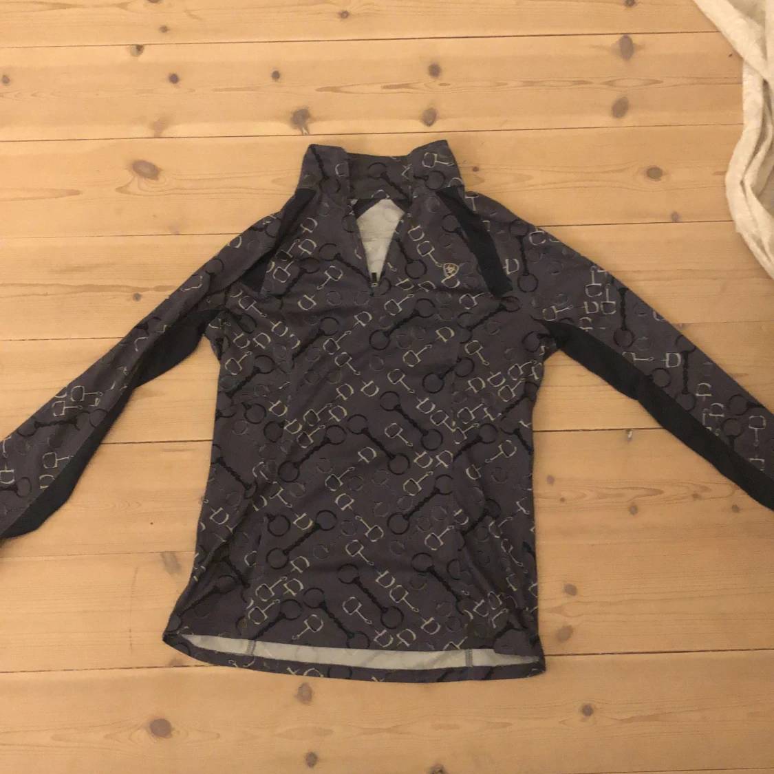 Grå ridtröja med olika bett på.