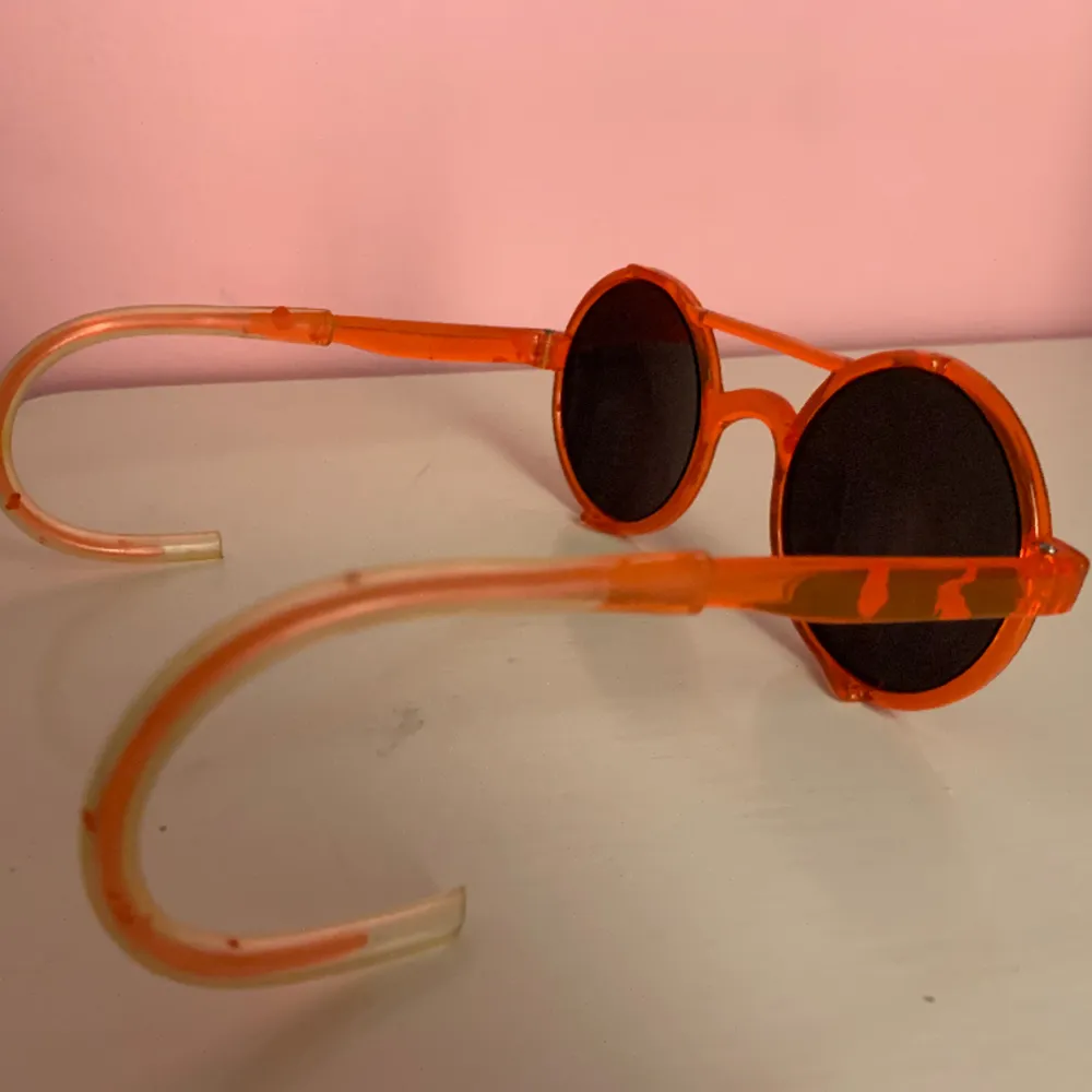 Ett par roliga/fula/snygga solglasögon i orange plast, speciella och lite unika och är nog från -80-90-talet.. Övrigt.