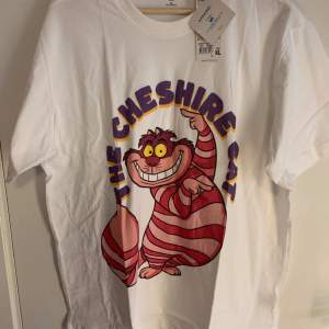 Ny Cheshire Disney t-shirt, Alice in Wonderland. Storlek XL = 72cm från Axel och ner, och 56cm mellan armhålorna 